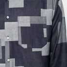Close-up of a patterned shirt with geometric shapes in gray and blue.