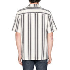 Person wearing a black and white striped shirt on a plain background