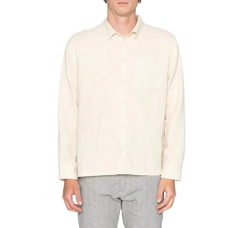Person wearing a light-colored shirt and gray pants on a white background