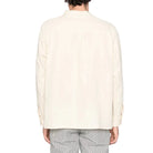 Person wearing a light-colored shirt on a white background