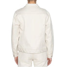 Person wearing a light-colored shirt and pants on a white background