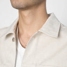 Close-up of a person wearing a light-colored shirt with a collar.