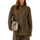 Woman wearing a brown outfit holding a clutch on a white background