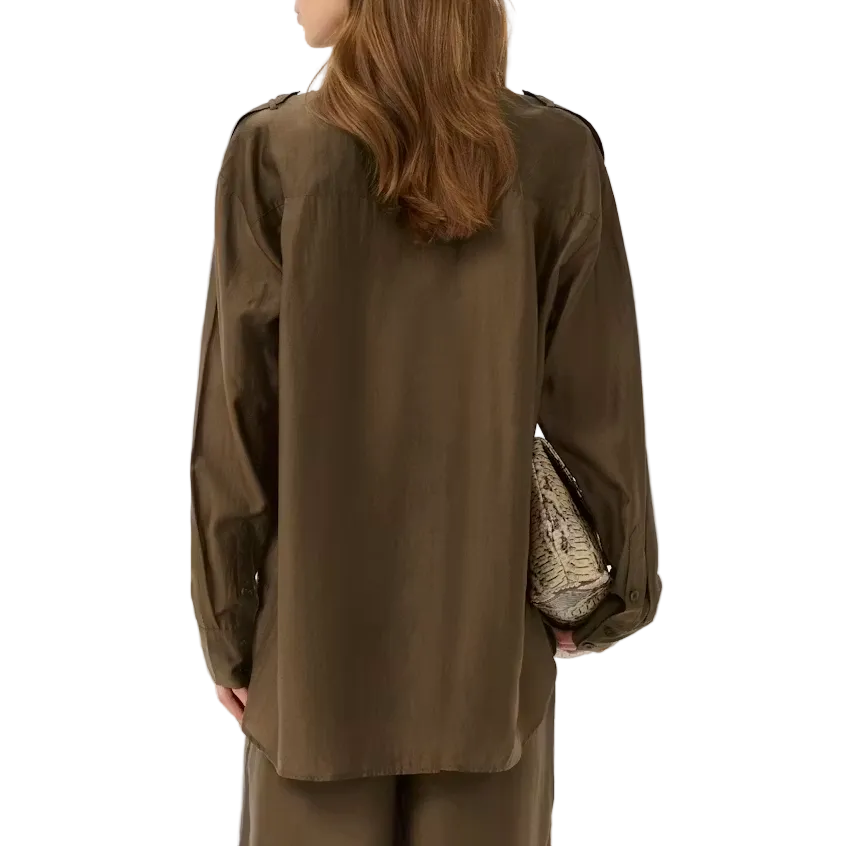 Woman wearing a brown outfit holding a patterned bag on a white background