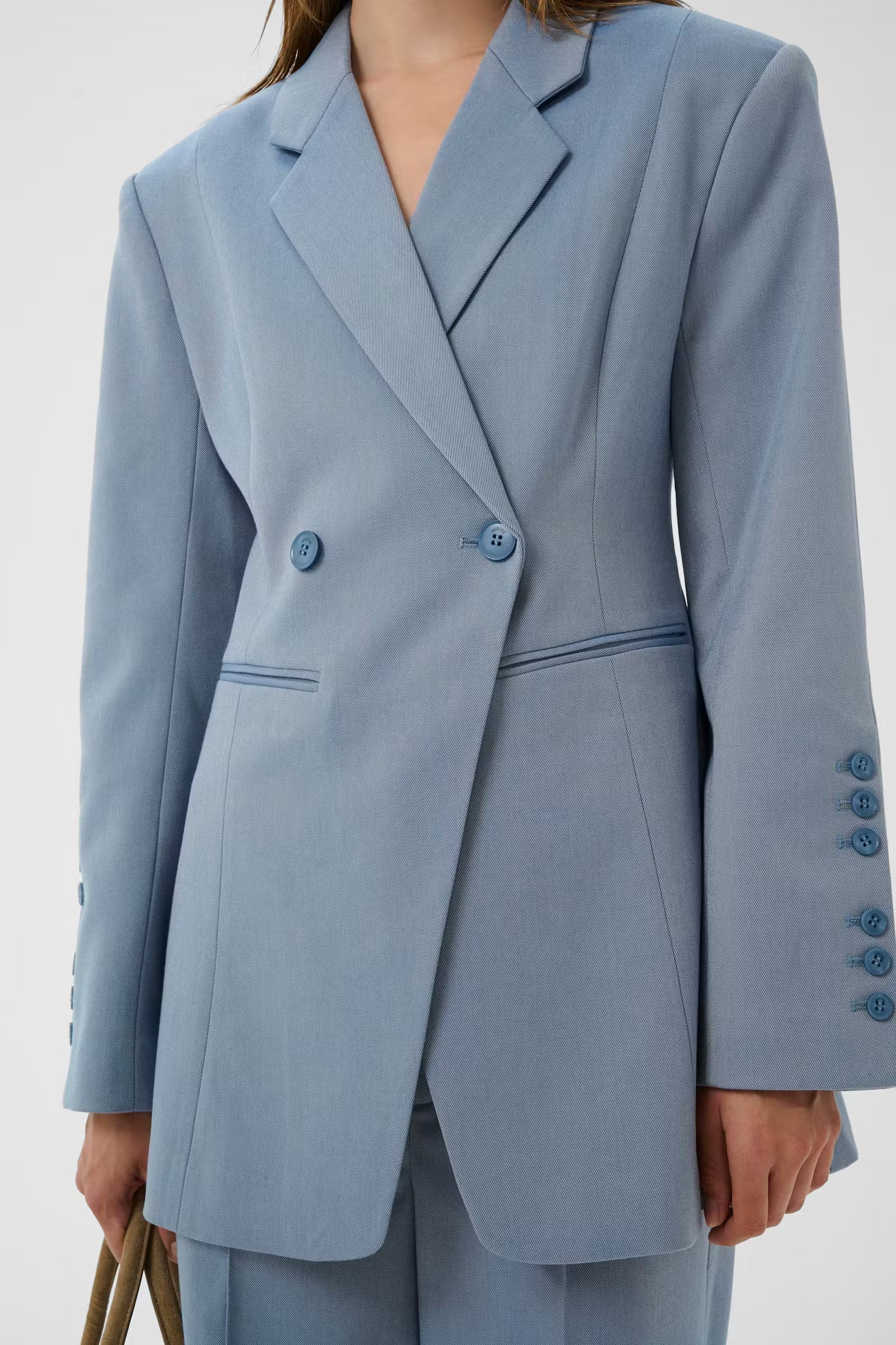 Light blue suit jacket with matching pants on a white background