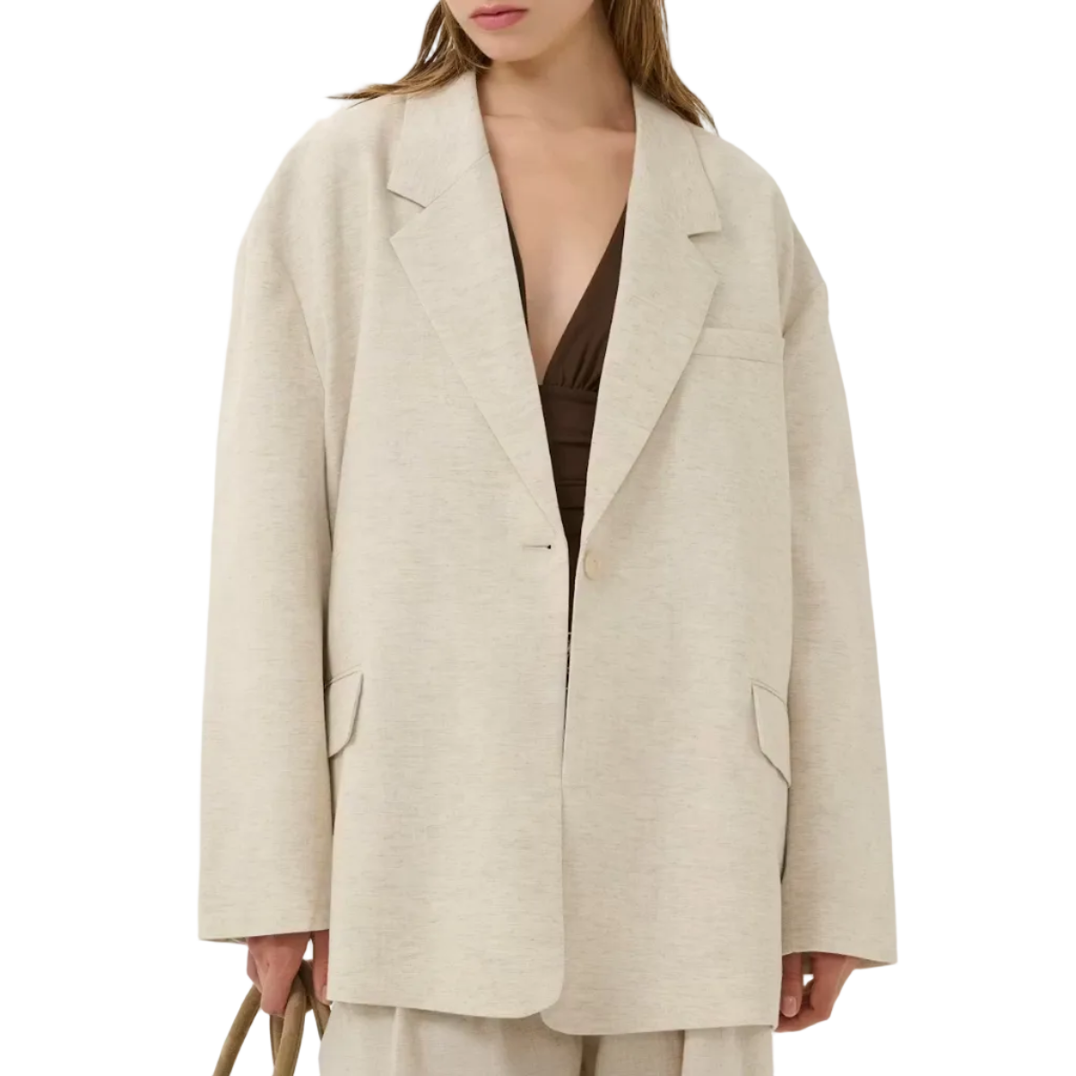 Woman wearing a beige blazer and pants with a plain background