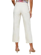 Person wearing white pants and a floral top on a white background