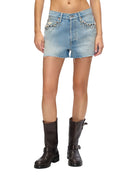 Model wearing light blue denim shorts and boots on a white background