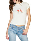 Woman wearing a white t-shirt with red shoes design and blue jeans on a plain background