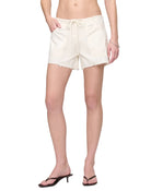 Person wearing beige shorts on a plain background