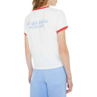 Woman wearing a white t-shirt with red trim and blue pants on a white background