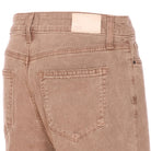 Close-up of brown pants with a visible brand label on a white background