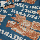 Close-up of a shirt with vintage-style graphics and text on a blue background