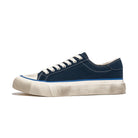 navy low top sneaker with white sole on a white background