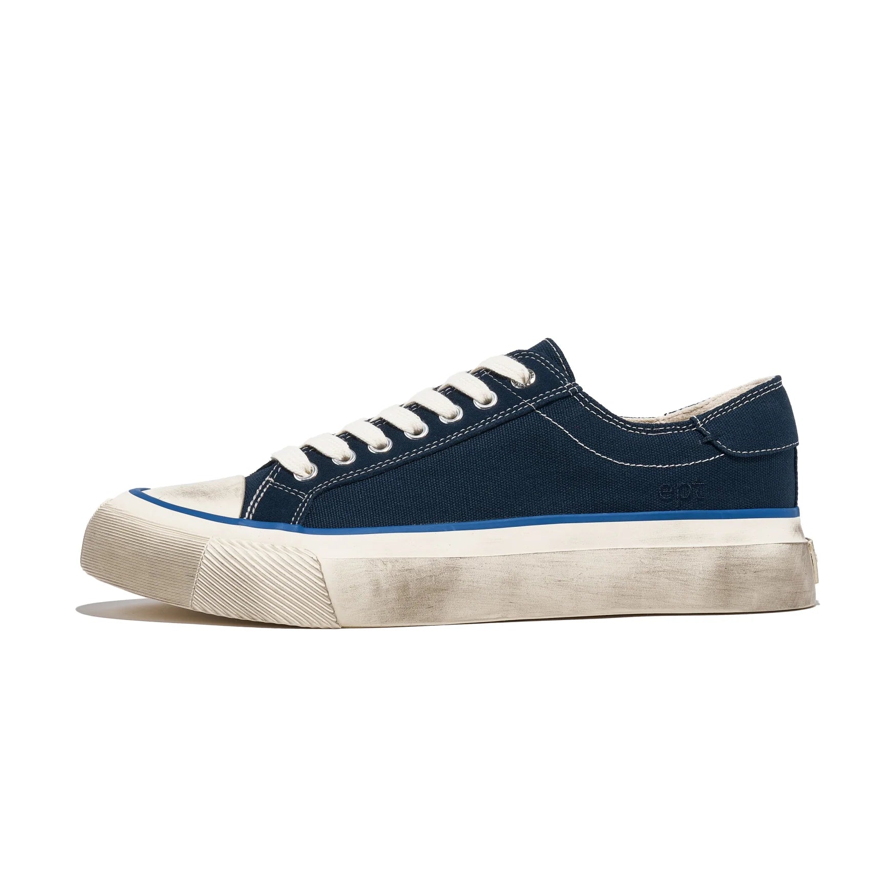 navy low top sneaker with white sole on a white background
