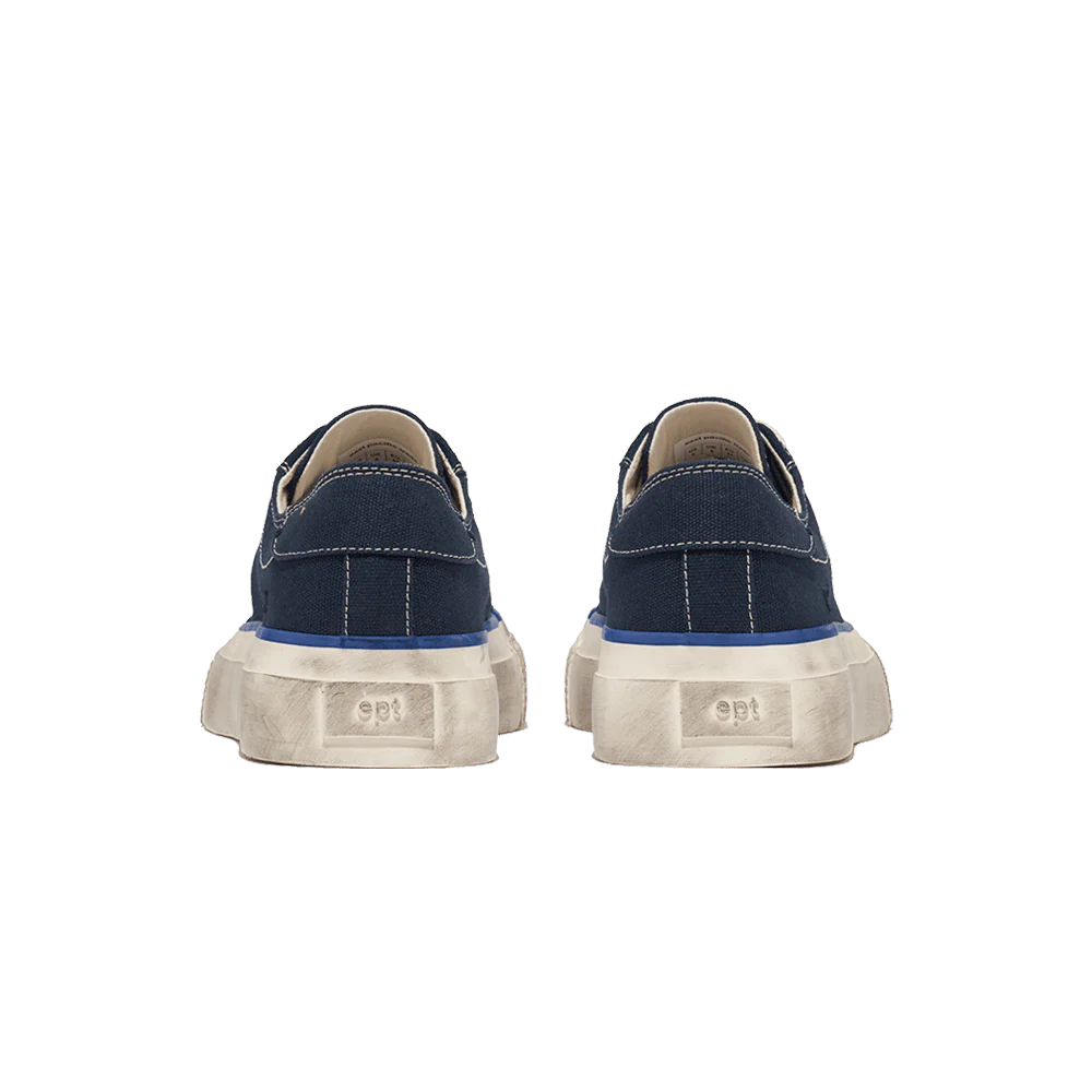 Pair of navy blue sneakers with white soles on a white background