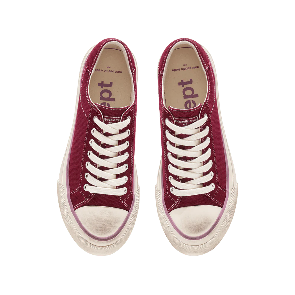 Pair of red sneakers with white laces on a white background