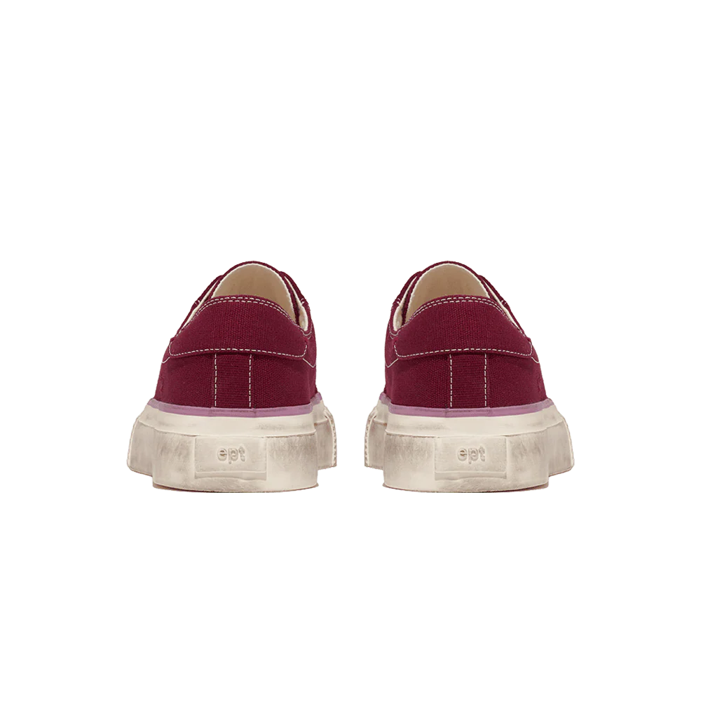 Pair of red sneakers with white soles on a white background