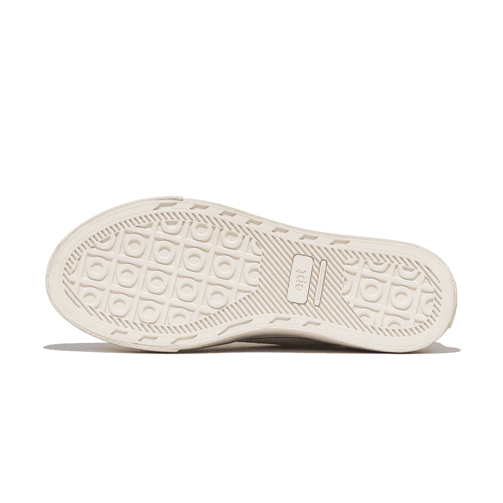 White sneaker sole with patterned tread on a white background