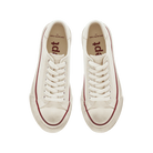 Beige sneakers with red soles on a white background