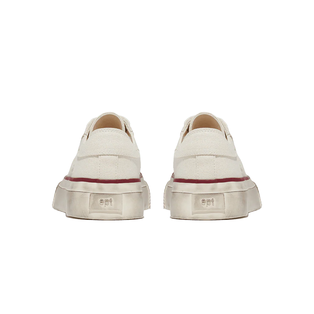 Pair of beige sneakers with a red sole on a white background