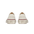 Pair of beige sneakers with a red sole on a white background