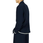 Person wearing a navy blue blazer on a white background