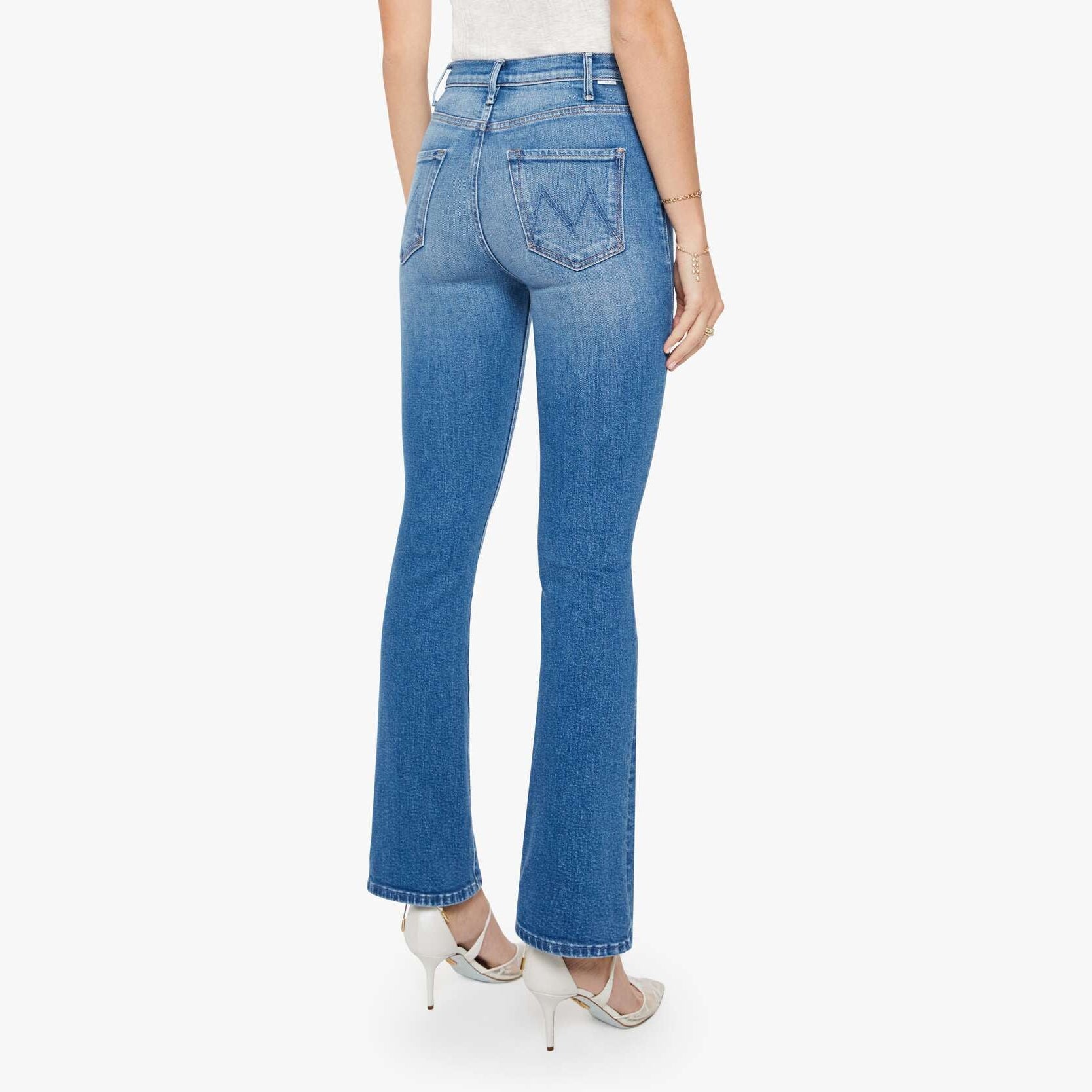 Woman wearing blue jeans and a white top on a white background