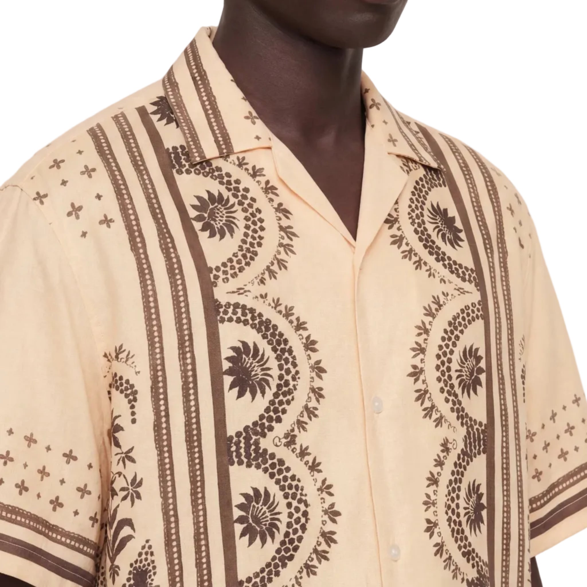 Beige shirt with brown geometric patterns worn by a person on a white background
