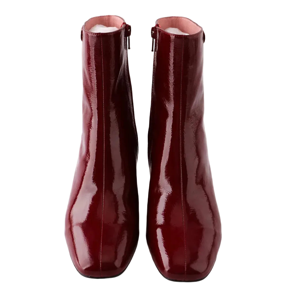 Pair of red patent leather ankle boots on a white background