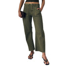 Woman wearing a green top and wide-leg pants against a plain background