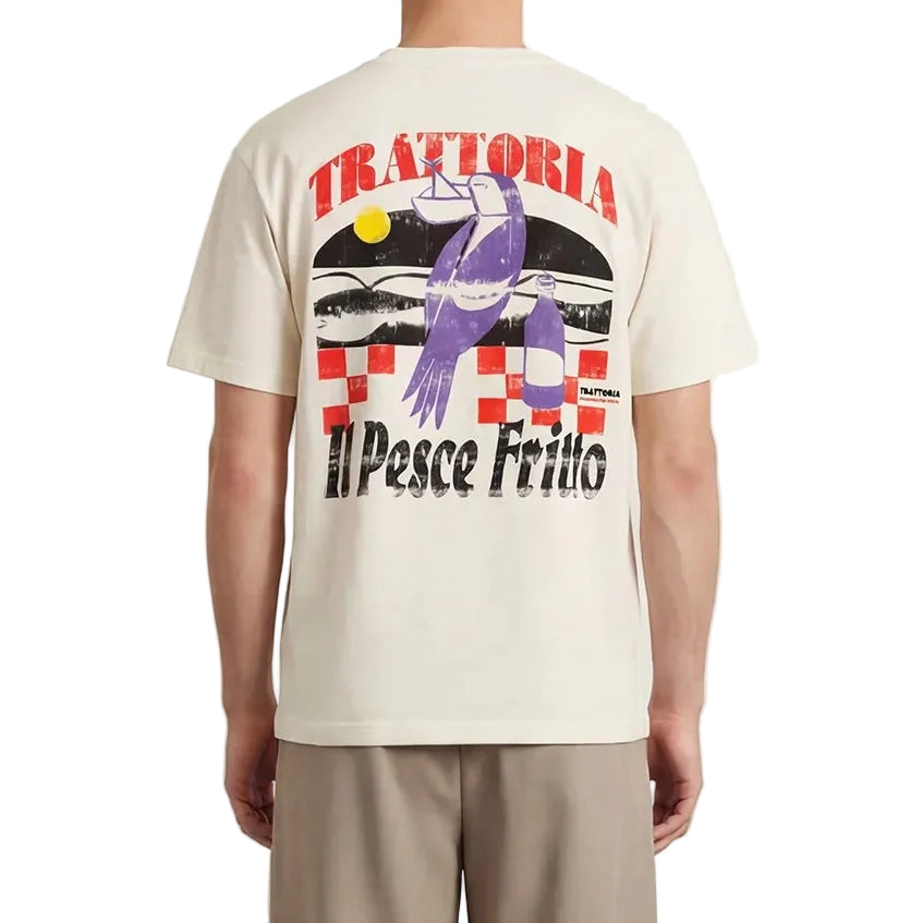 Person wearing a cream t-shirt with colorful graphics and text, standing against a plain background