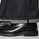 Close-up of a cuffed dark blue jean on a white background