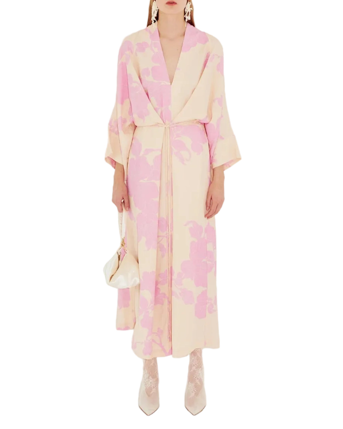Person in a beige kimono style dress with a pink floral pattern on a white background