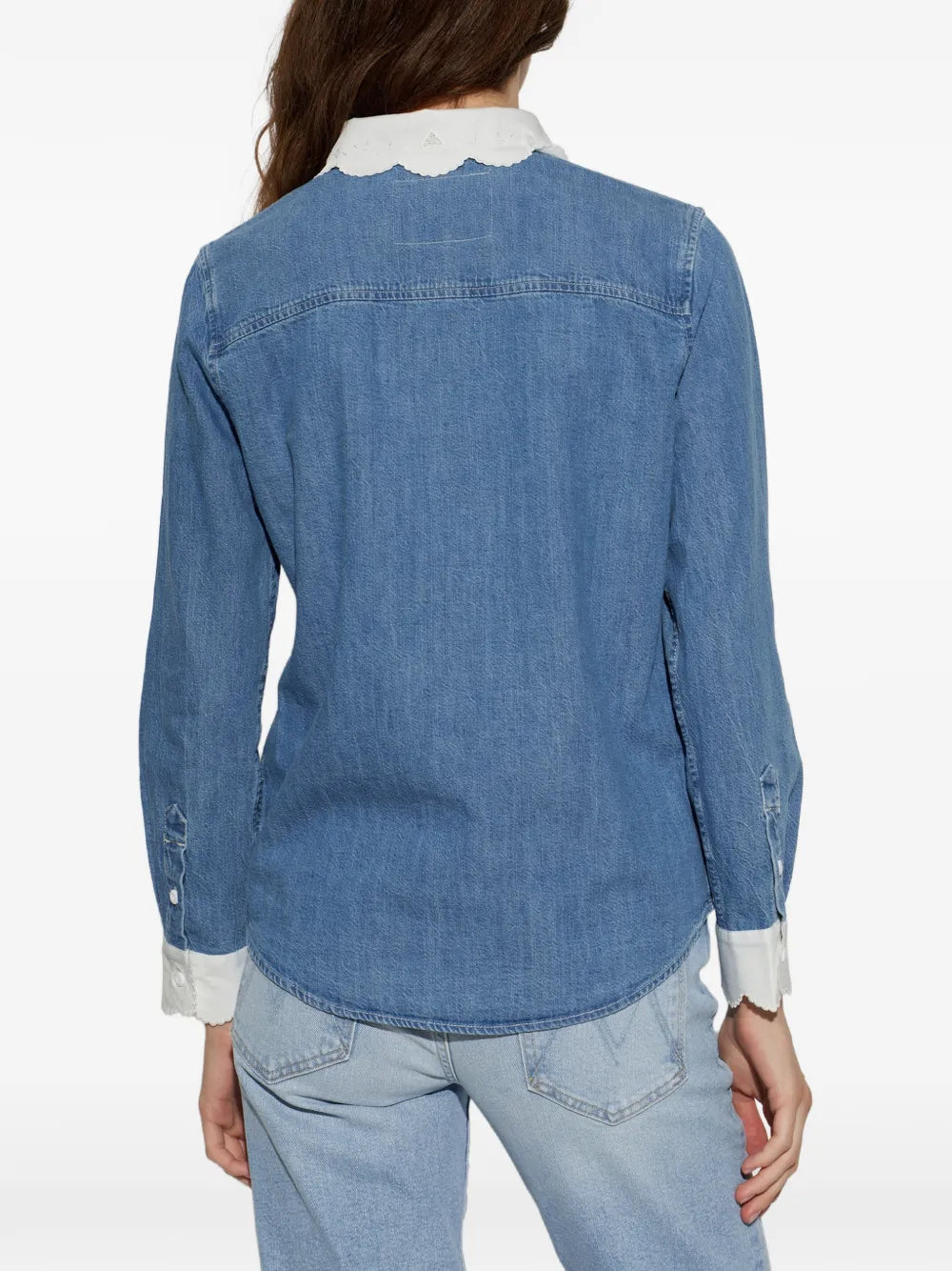 A woman shown from the back wearing a medium-wash blue denim shirt with a contrasting white scalloped collar and white rolled cuffs, paired with light-wash jeans against a plain white background.