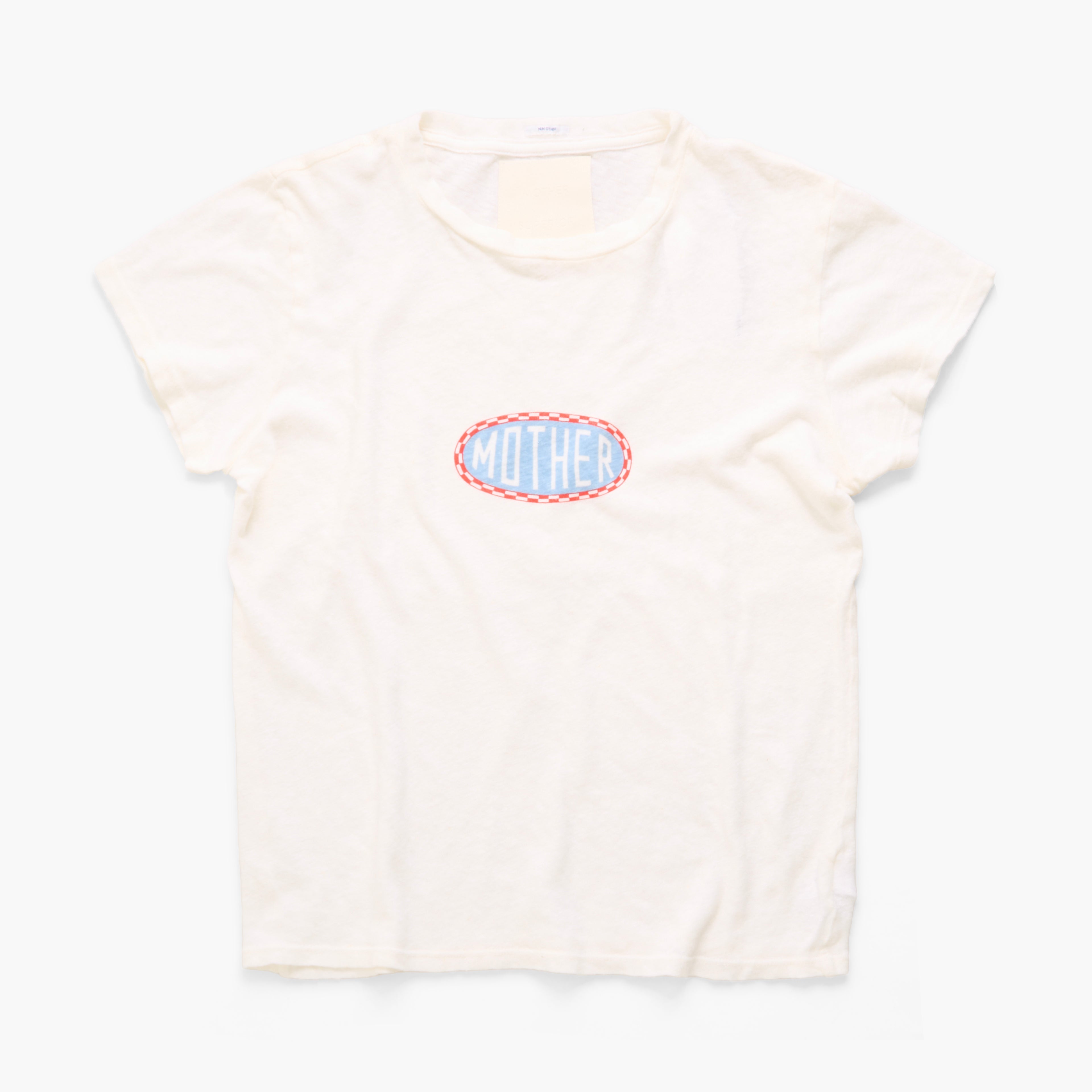 An off-white short-sleeve t-shirt with a central graphic that reads 'MOTHER' in light blue letters inside a scalloped red and blue oval, displayed on a clean white background.