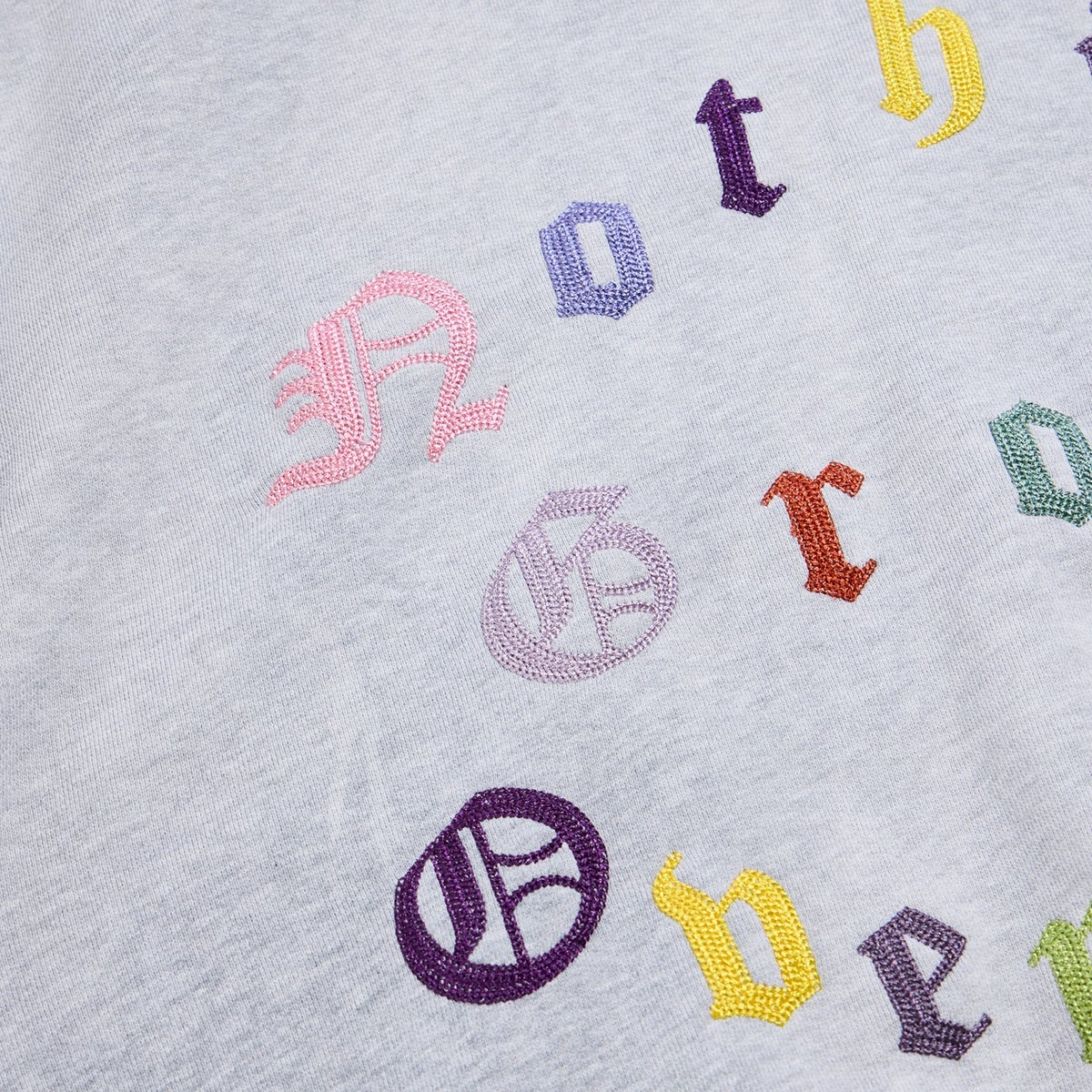 Embroidered colorful letters on a gray fabric background