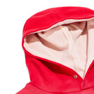 Close-up of a red hooded garment with beige interior lining on a white background