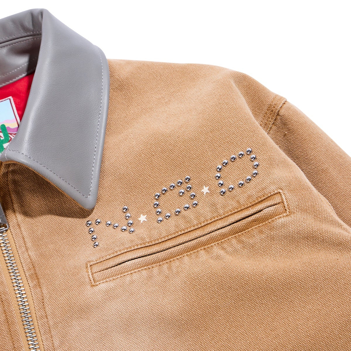 Close-up of a tan jacket with decorative elements on a white background