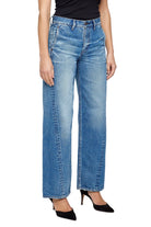 Person wearing blue jeans on a plain background