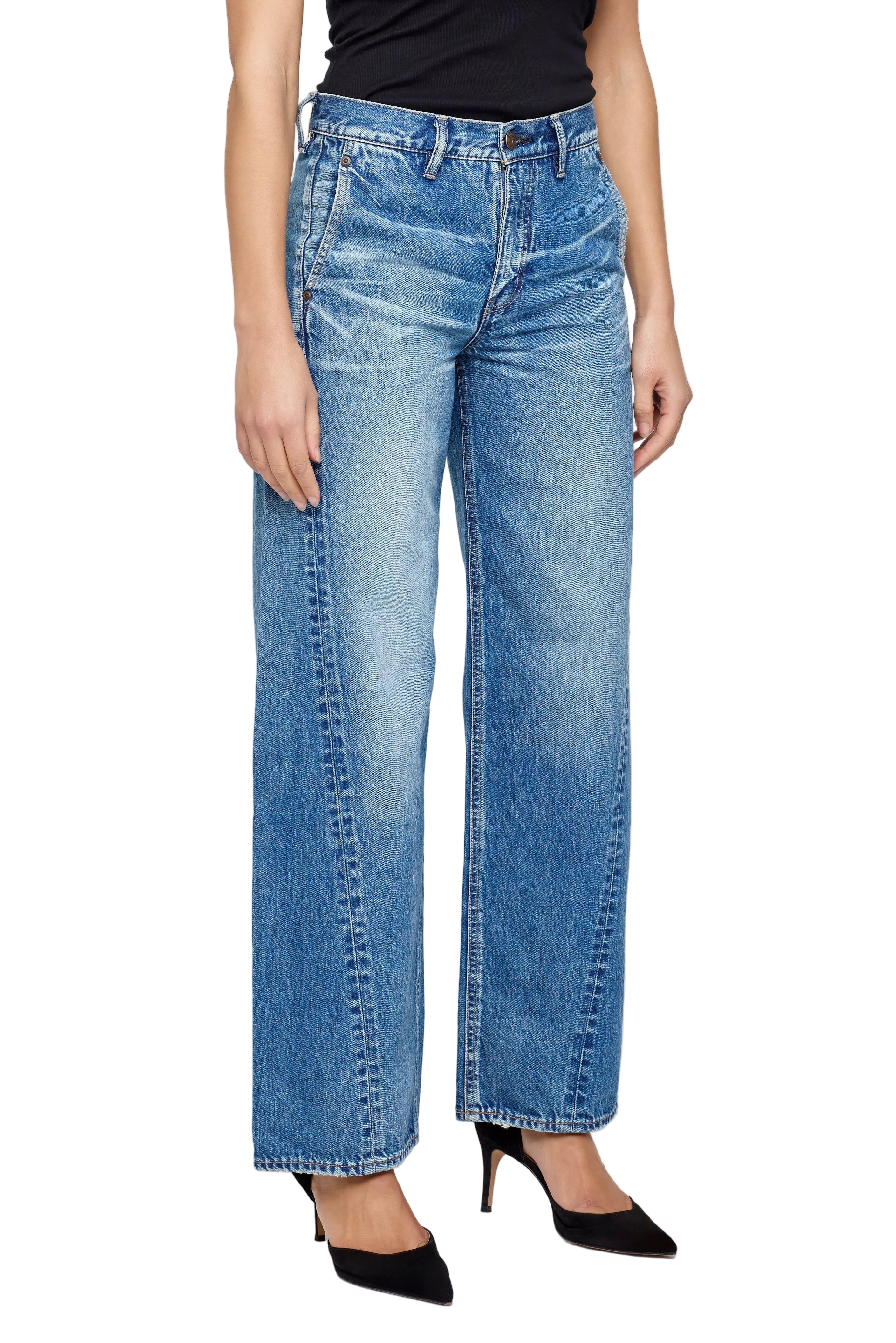 Person wearing blue jeans on a plain background
