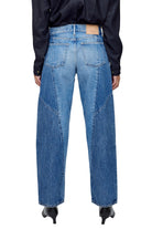 Person wearing blue jeans on a plain background