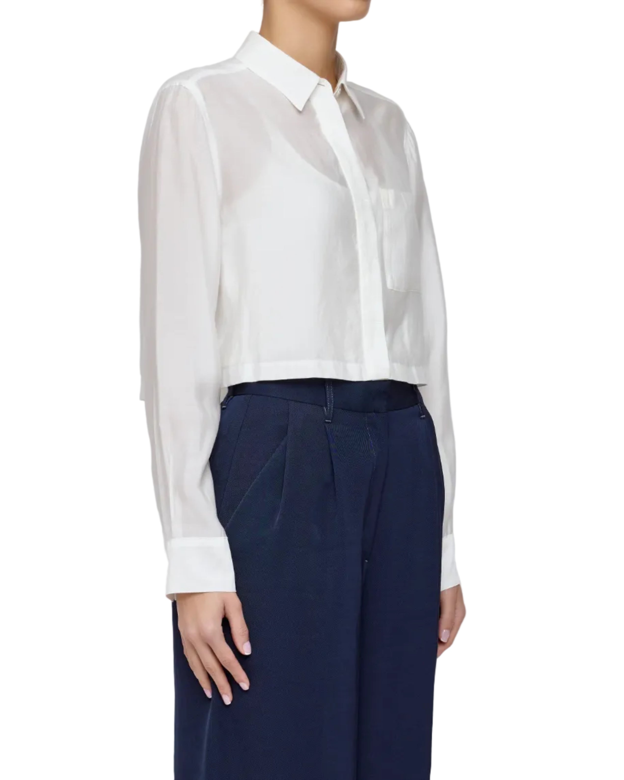 Person wearing a white blouse and navy pants on a white background