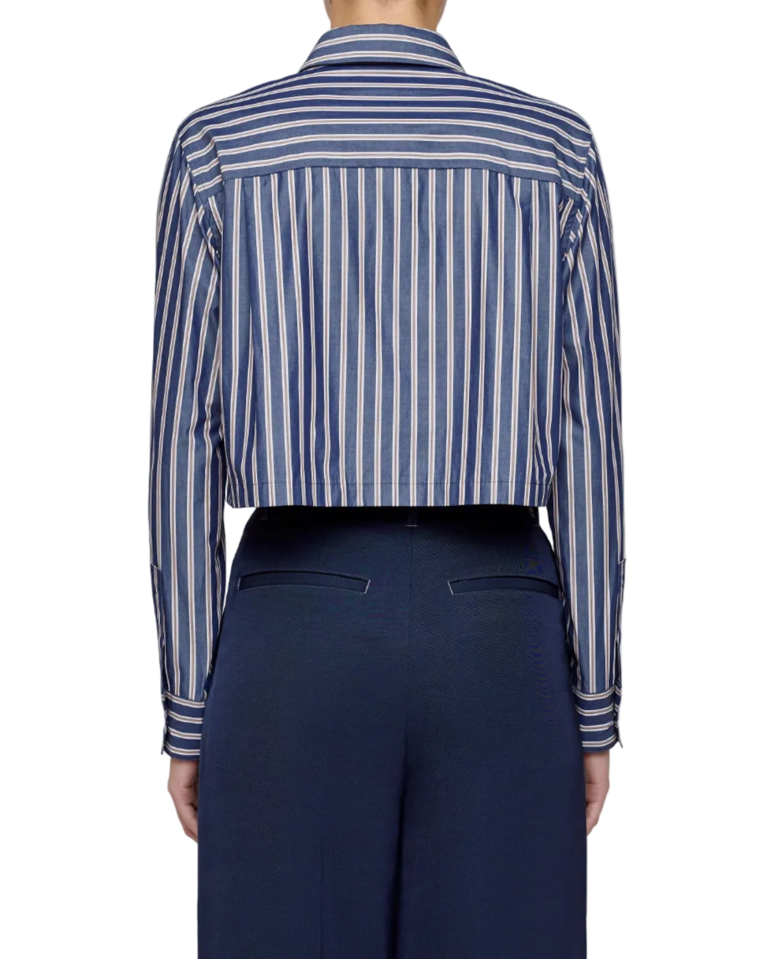 Person wearing a blue and white striped shirt with navy pants on a light gray background