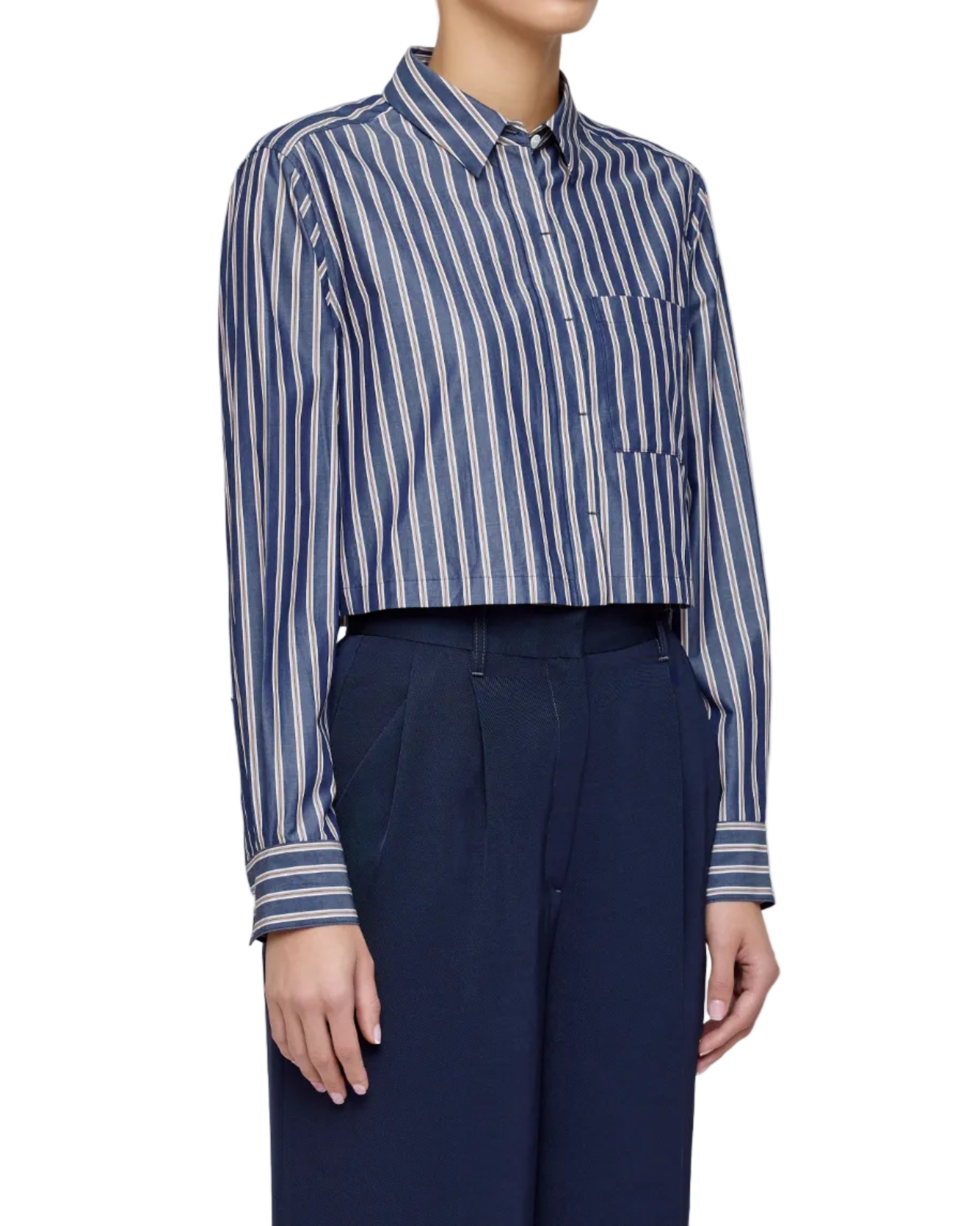 Person wearing a blue and white striped shirt with navy pants on a light gray background