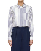 Person wearing a white and blue striped shirt with navy pants on a plain background
