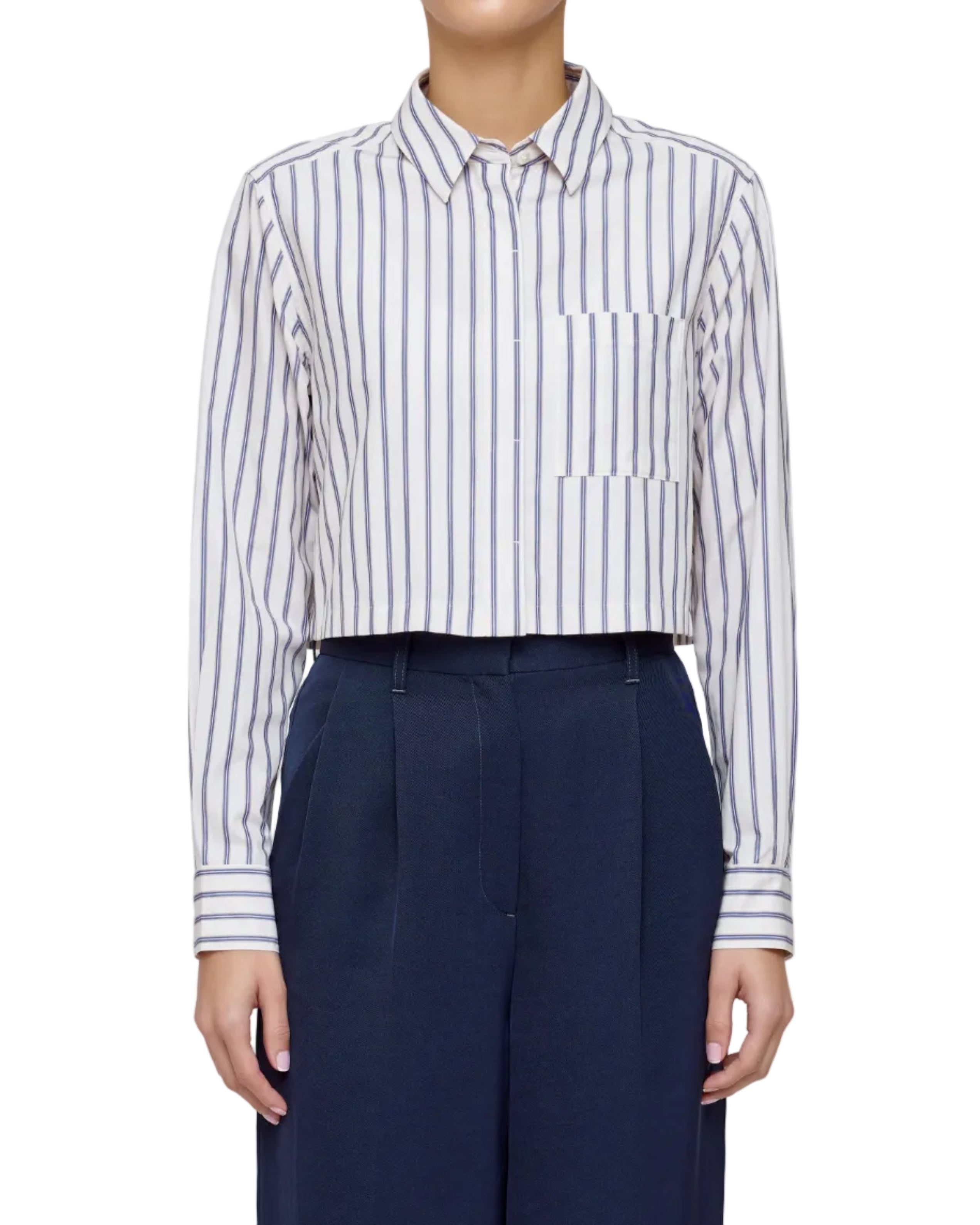 Person wearing a white and blue striped shirt with navy pants on a plain background
