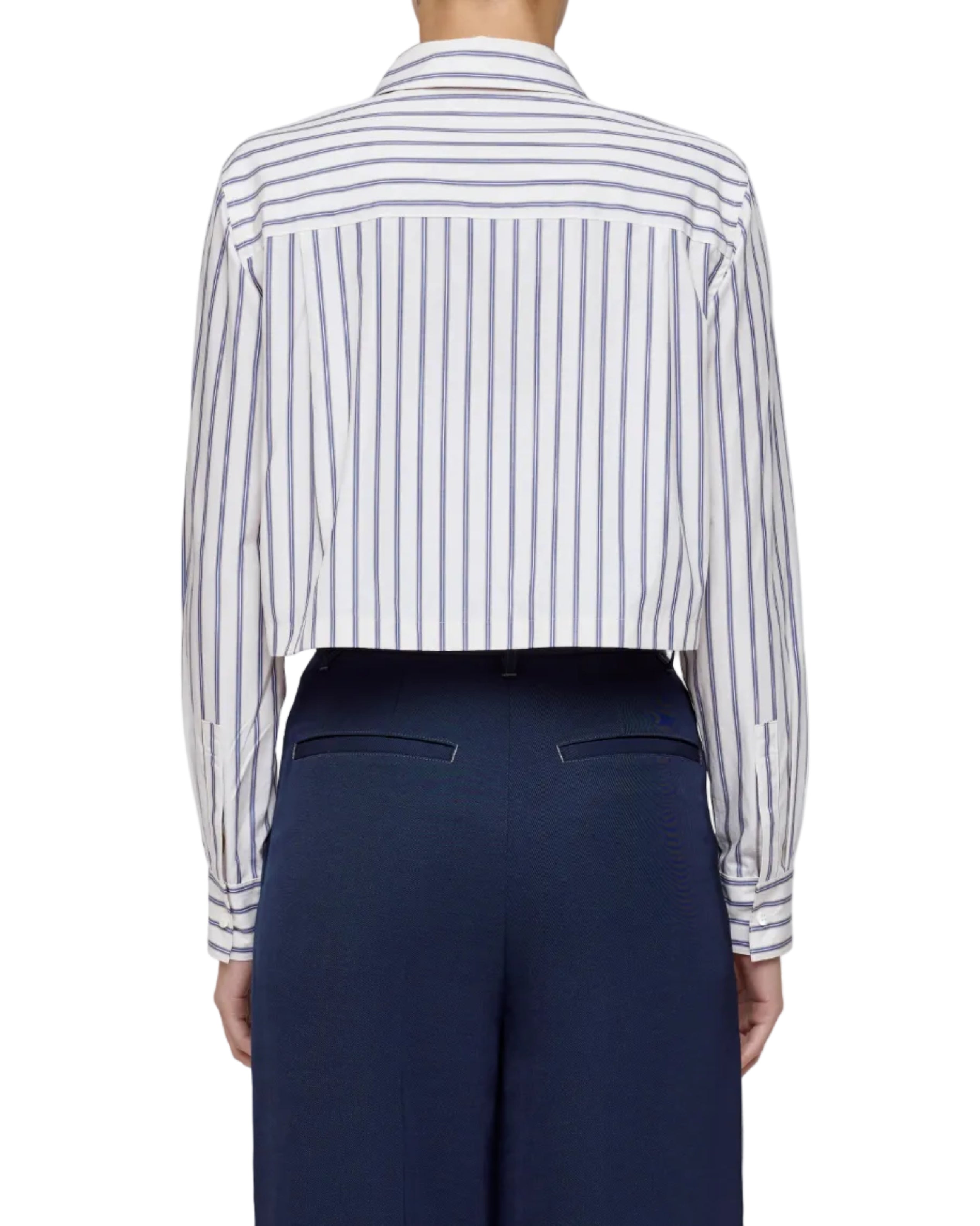 Person wearing a striped shirt and navy pants on a light gray background
