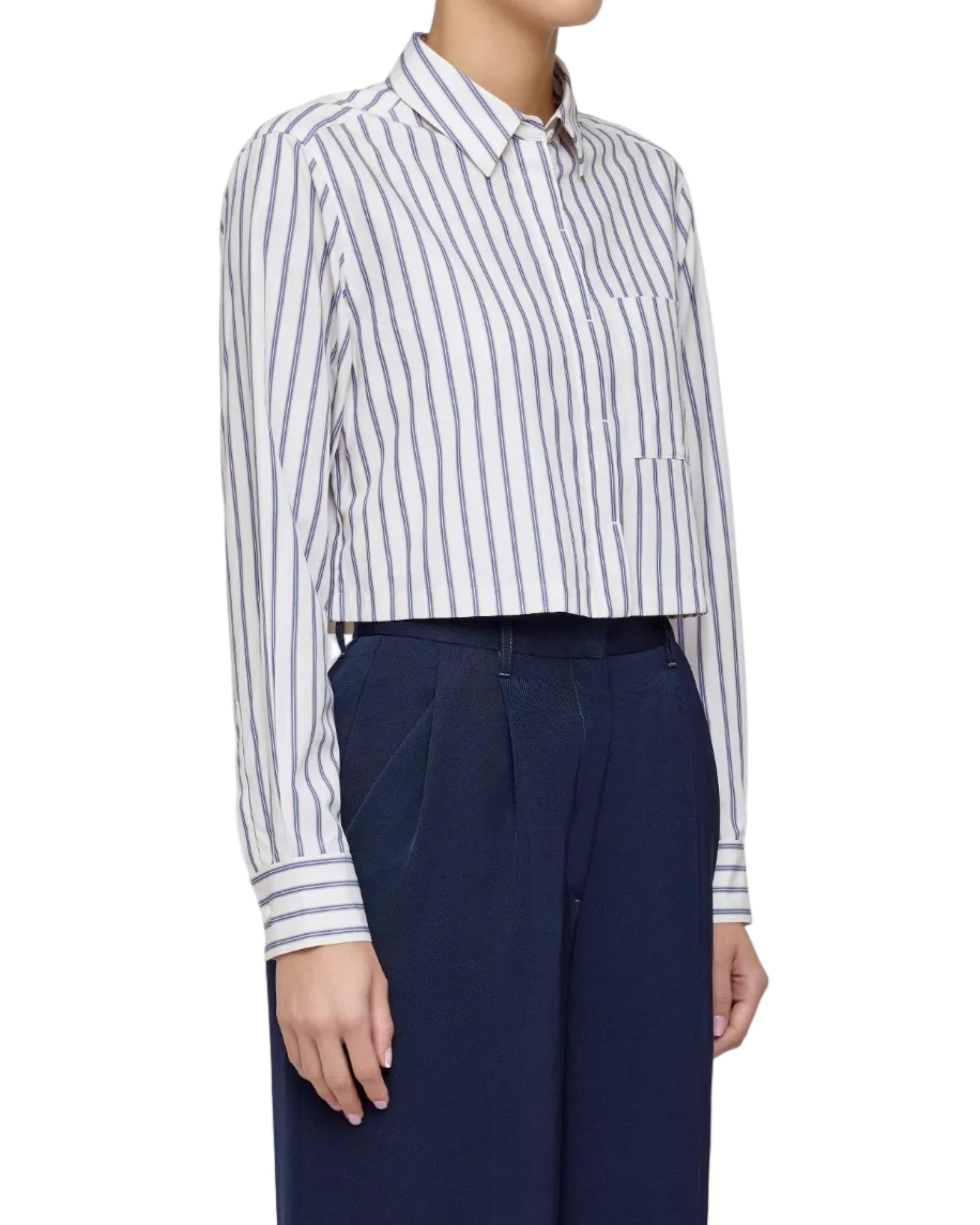 Person wearing a white and blue striped shirt with navy pants on a light gray background