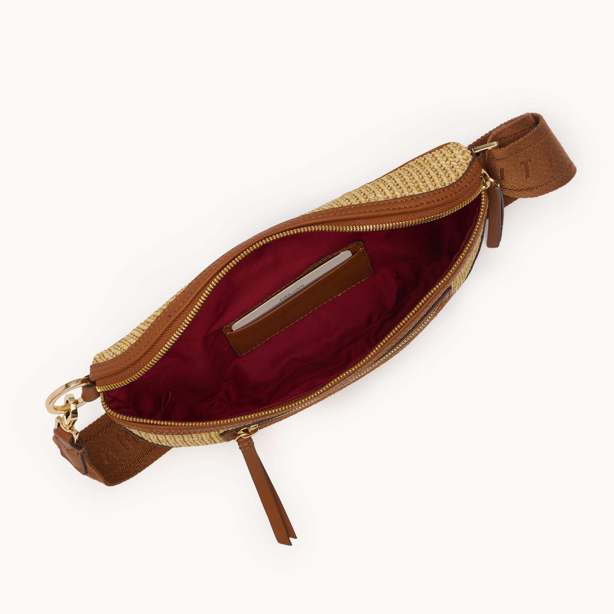 Interior view of a tan crossbody bag with brown accents on a white background 